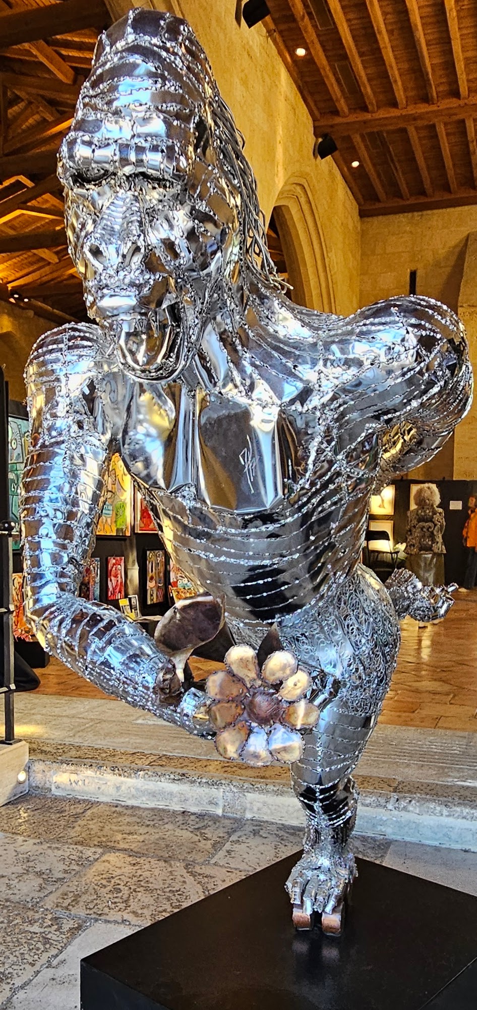 Bold mirrored sculpture of gorilla offering flowers