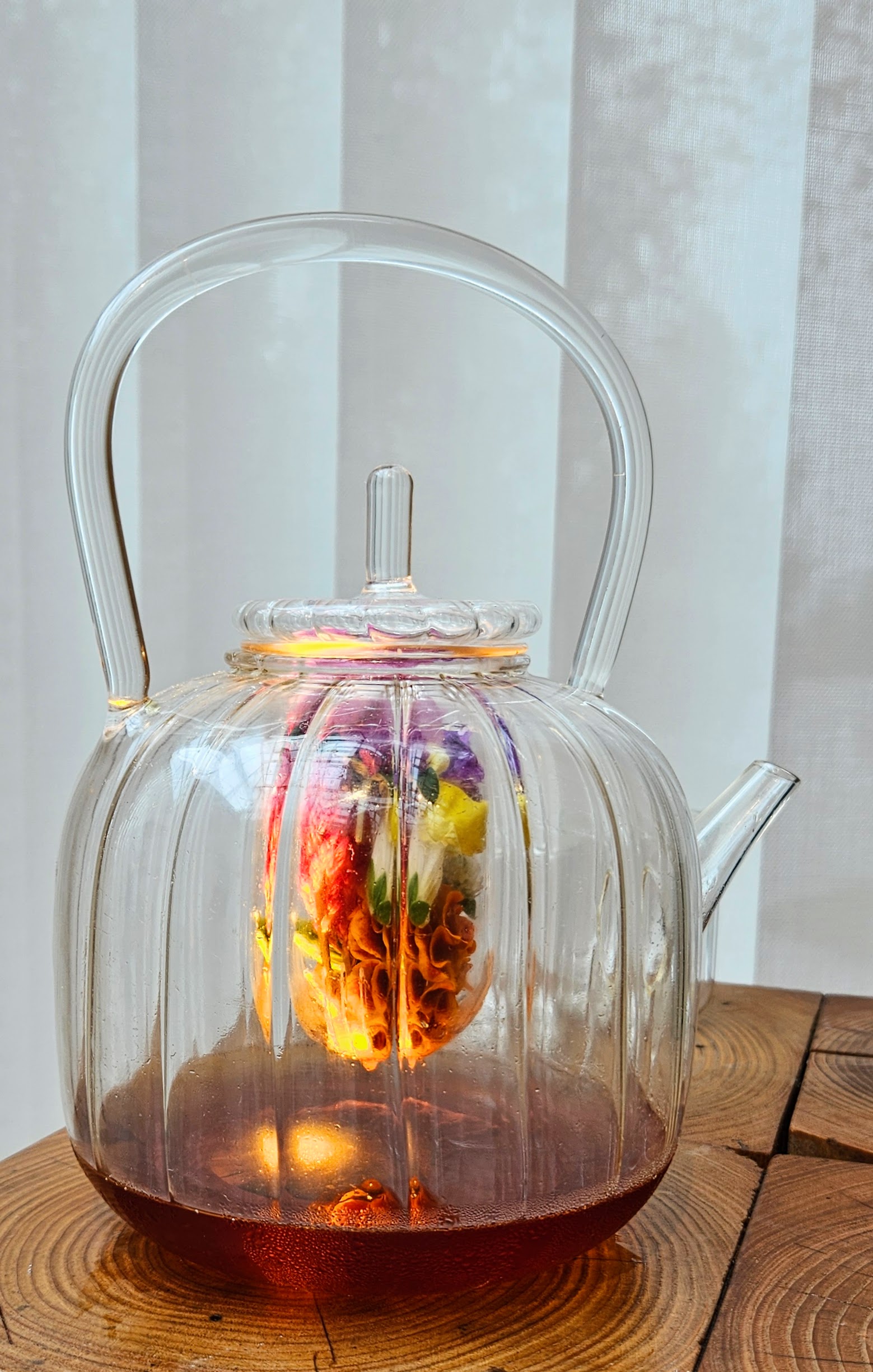 Glass teapot of cider and flowers