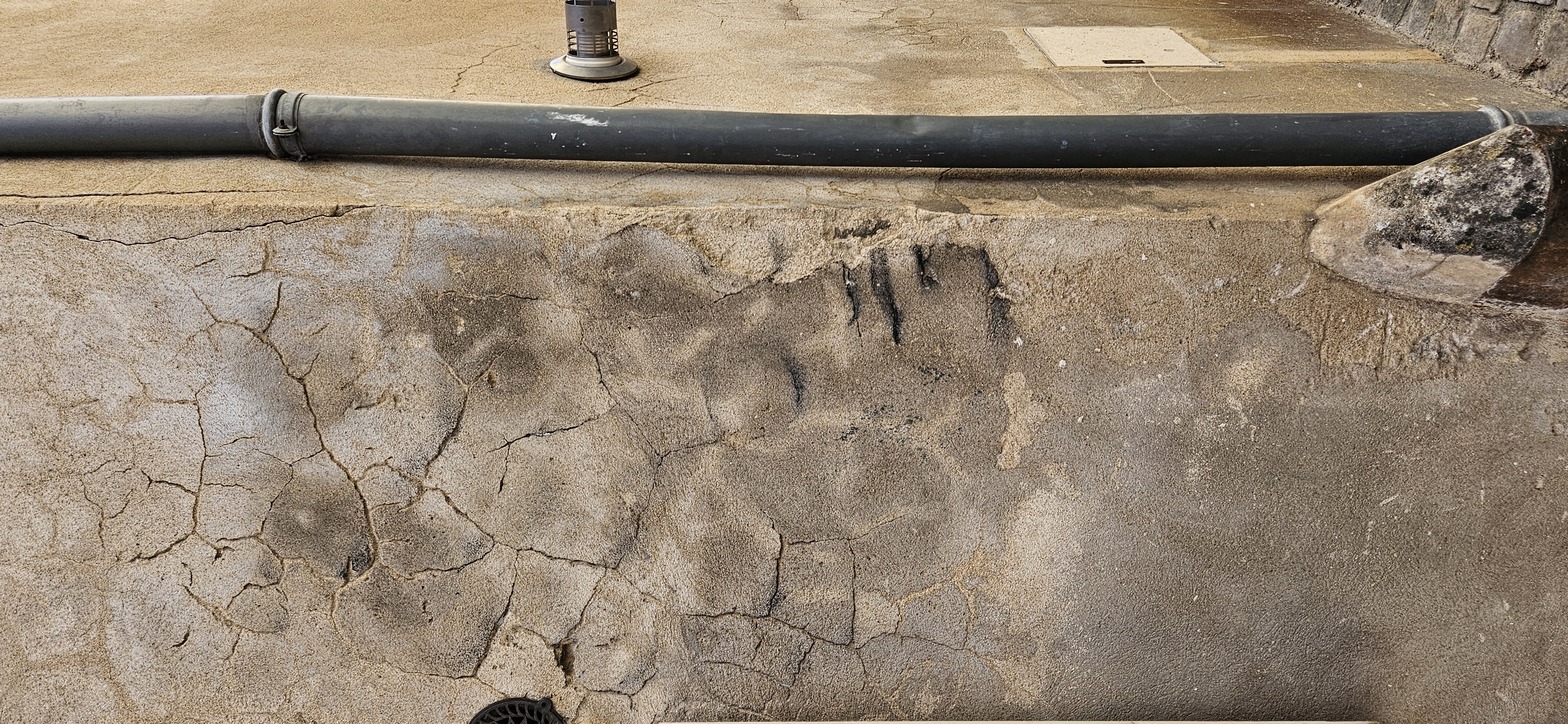 Subtle street art face blending into cracks in stucco
