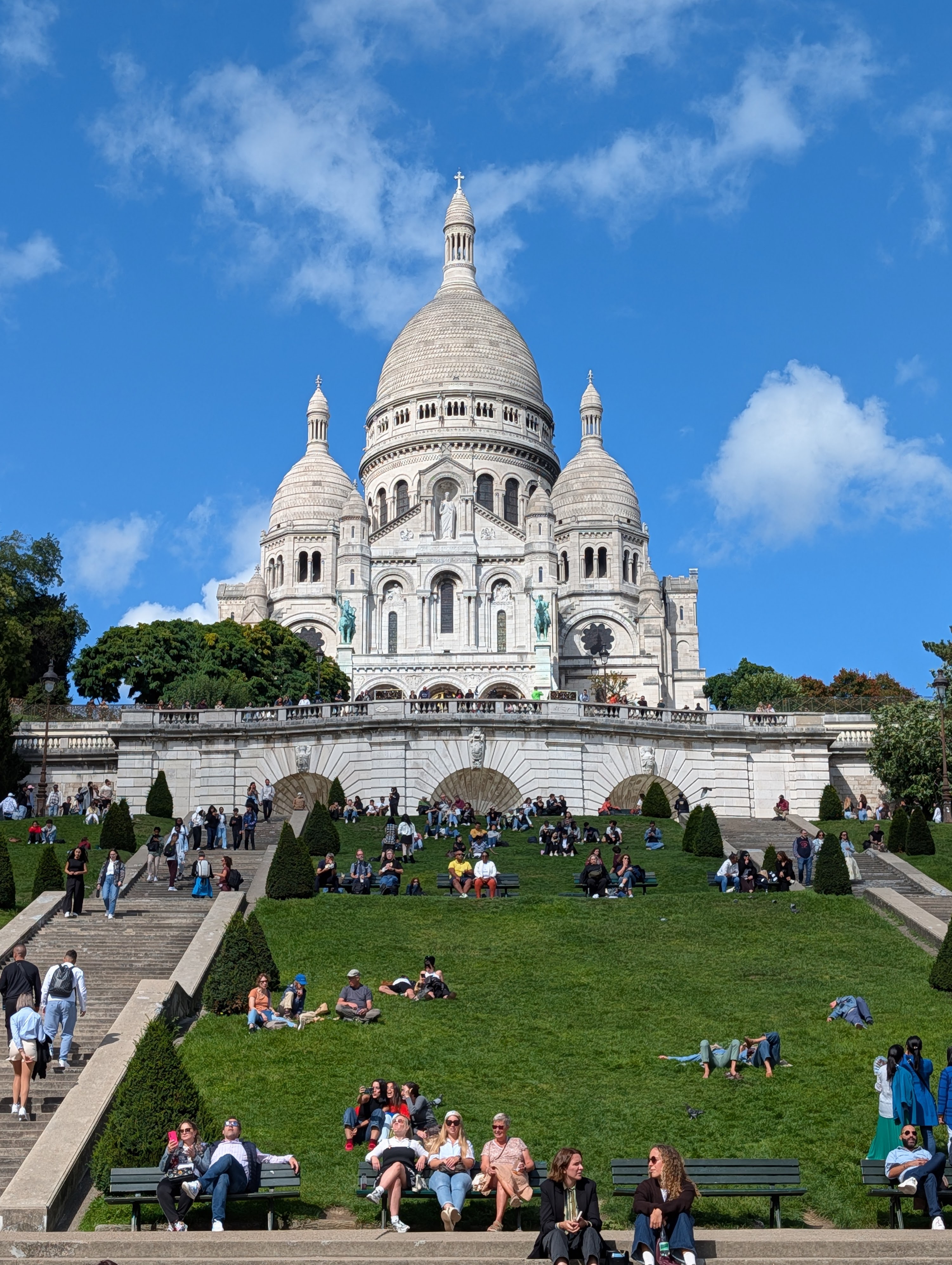 People enjoying the weather on the terraced lawn of Sacre-Coeur