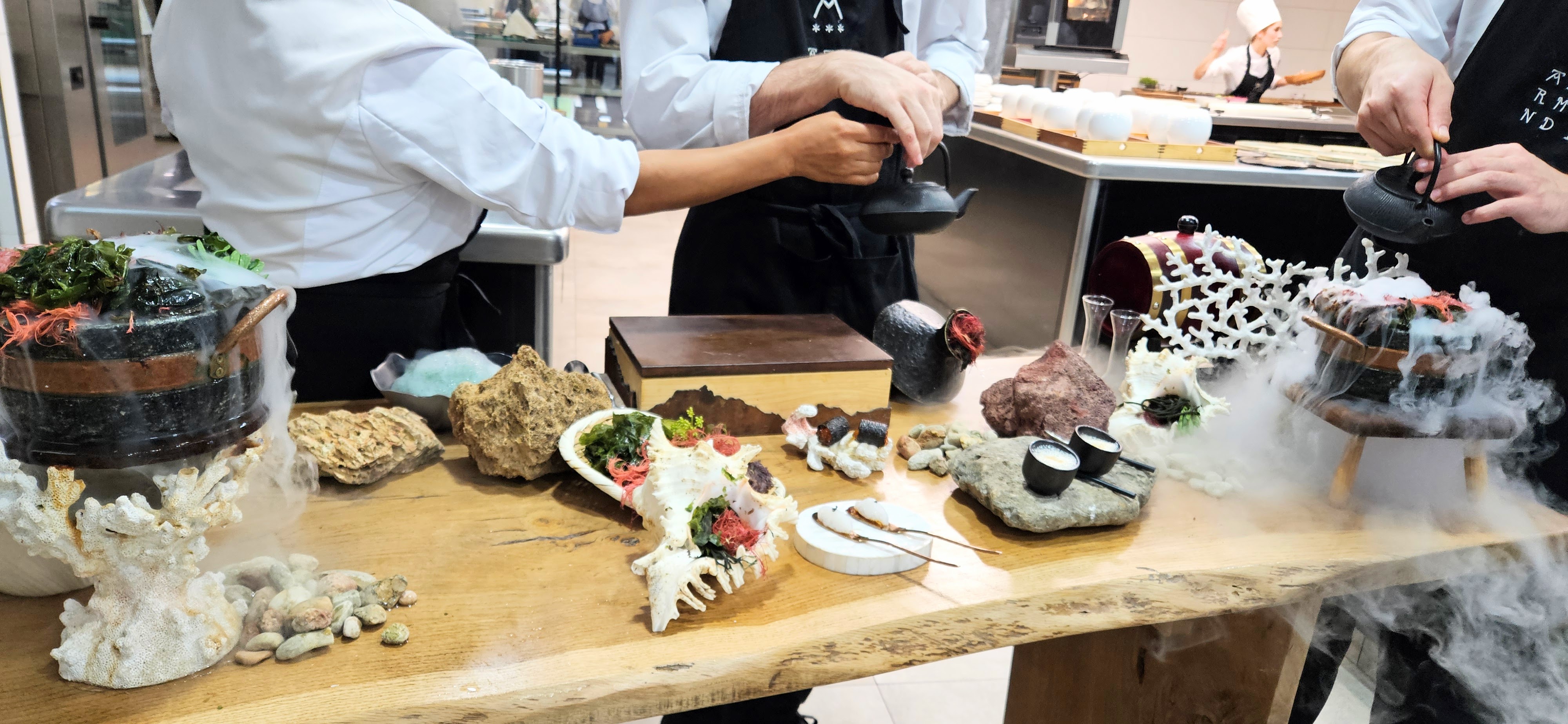 Table with seafood bites and dry ice pots set with seashells