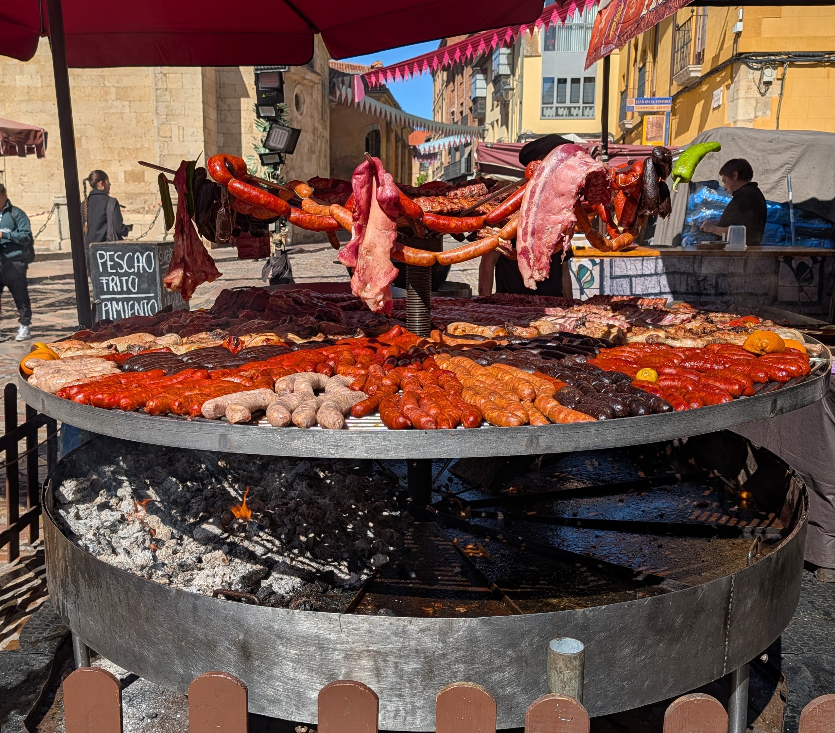 Giant circular grill with lots of different sausages and meats